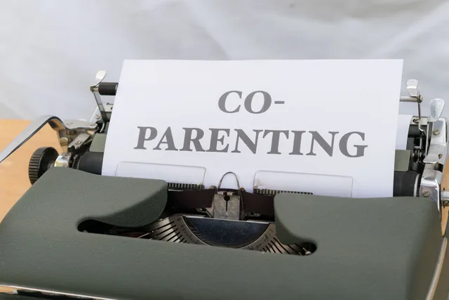 A vintage typewriter displaying a paper with the word 'Co-Parenting', symbolizing shared parenting or custody. Which family agreements tools are worth using
