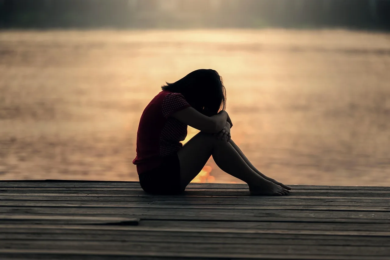 girl, sitting, jetty, docks, boardwalk, sad girl, young woman, female, sad, alone, lonely, nature, solitude, solitary, outdoors, sea, peaceful, silhouette, sunrise, sunset, teenager, water, woman. Four questions that sort ordinary mental wellbeing weather from something more