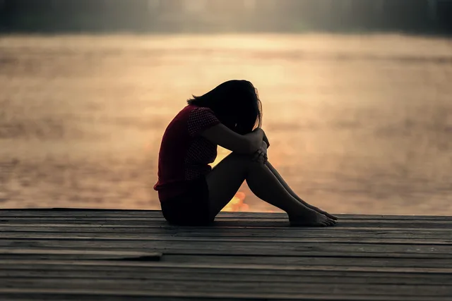 girl, sitting, jetty, docks, boardwalk, sad girl, young woman, female, sad, alone, lonely, nature, solitude, solitary, outdoors, sea, peaceful, silhouette, sunrise, sunset, teenager, water, woman. Four questions that sort ordinary mental wellbeing weather from something more