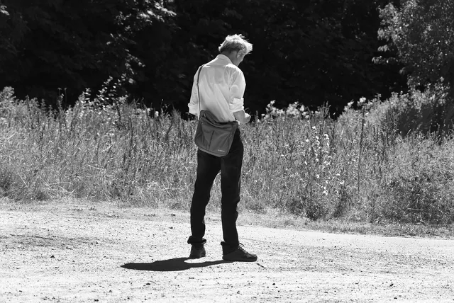 person, man, people, alone, solitary, standing, checking phone, footpath, outdoors, sunny day, white shirt, editorial, disney. Screen-time habits examples compared: the parts worth your attention, updated for 2027